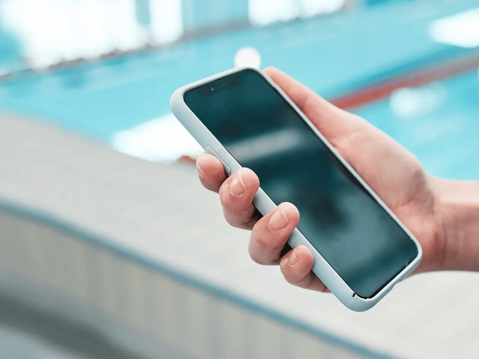 ManUsingPhoneNearPool_MacroHand_1600x1200