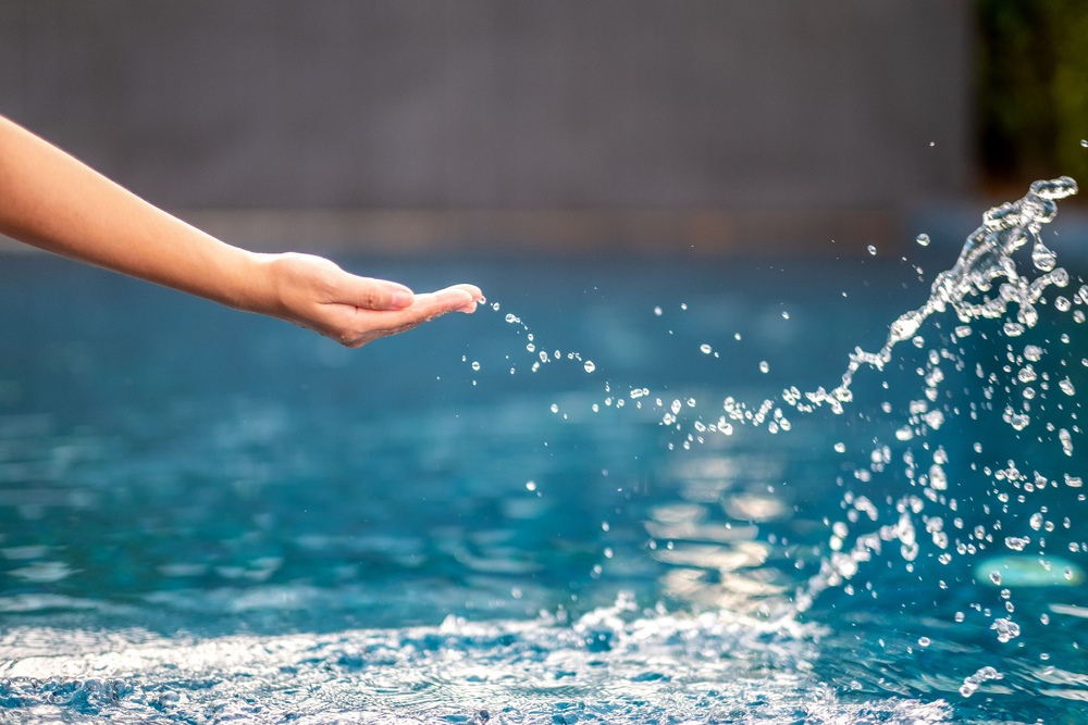 closeup-image-of-a-hand-splashing-water-in-the-poo-2023-11-27-04-51-06-utc-1-1