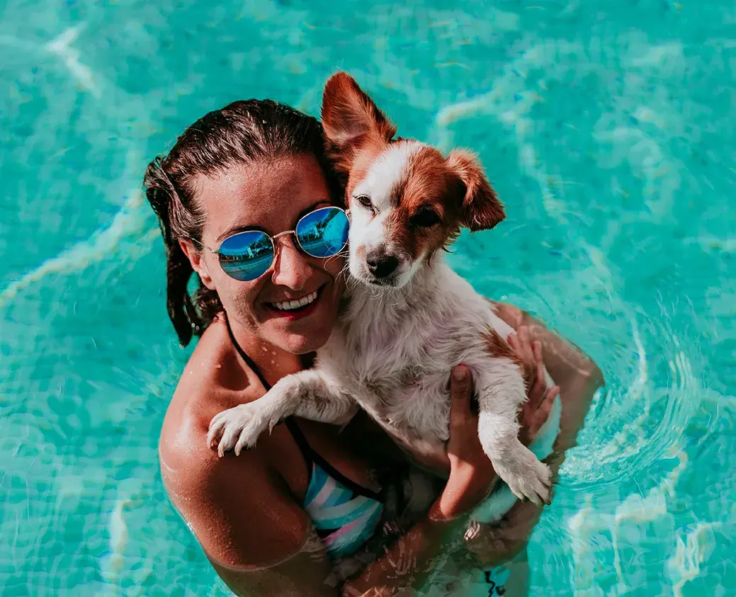 1039x843_WomanWithDogSwimmingPool