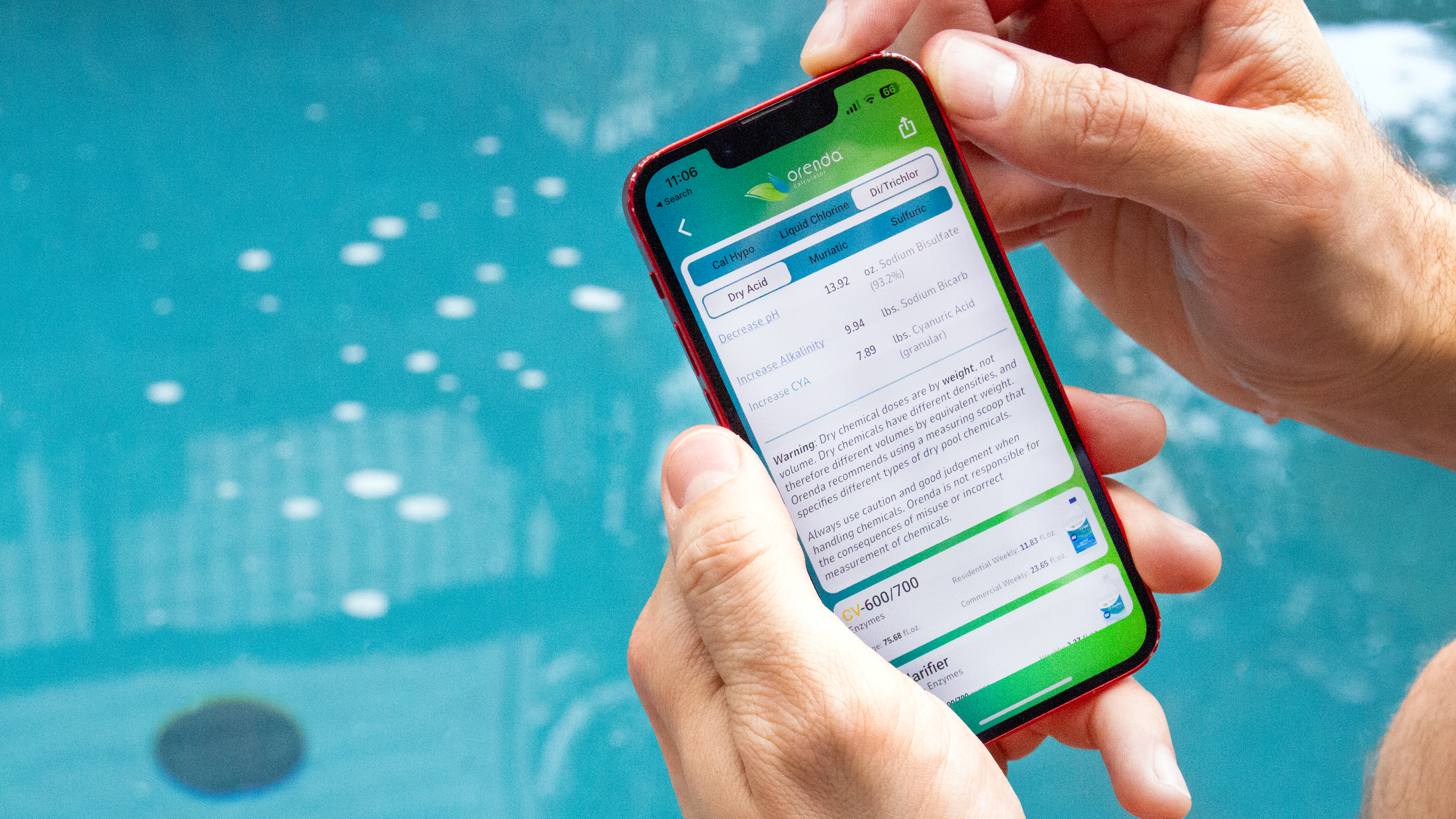 Close-up image of a person using the Orenda mobile app by the pool 
