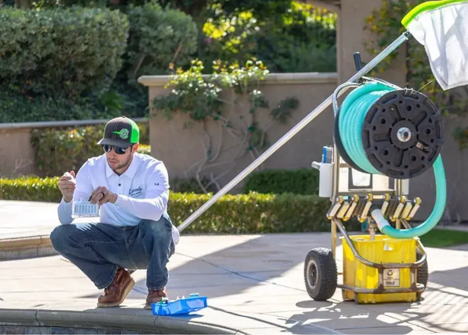 Pool professional testing water by pool with equipment